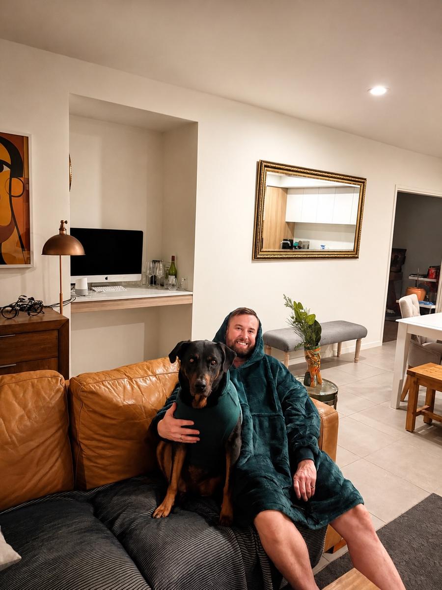 Customer in the green oversized hoodie blanket with his dog